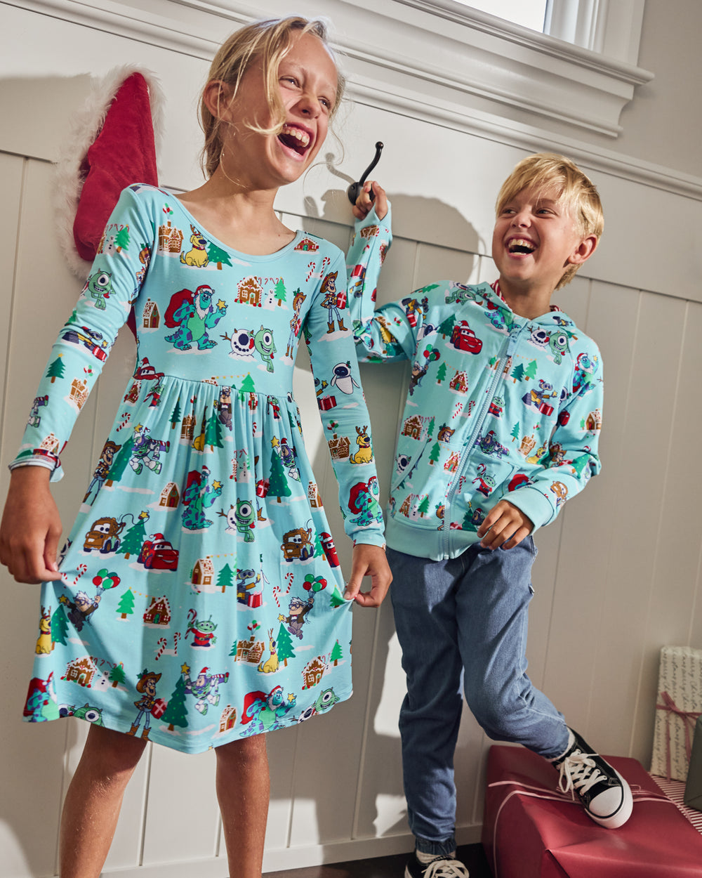 Two kids wearing matching Disney & Pixar Christmas Village play styles