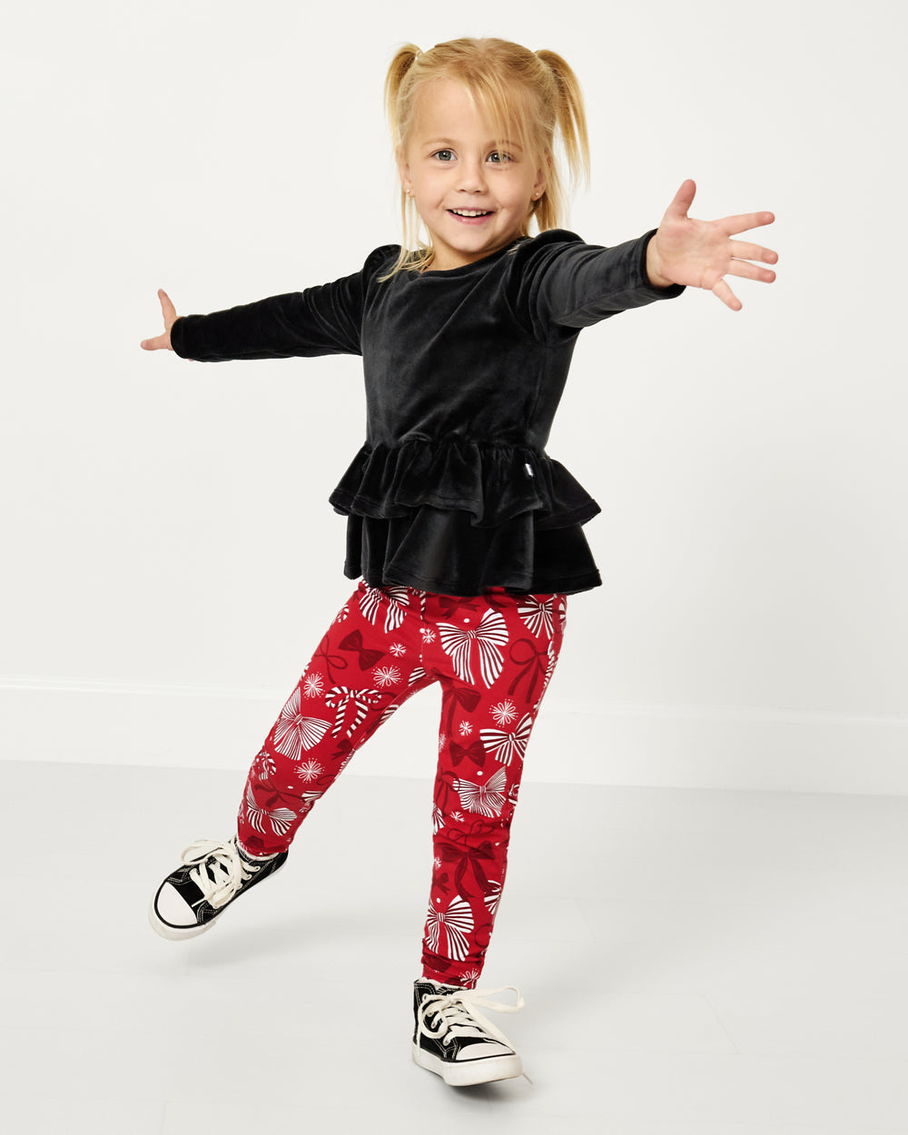 Posing girl wearing the Black Velvet Tiered Peplum Top