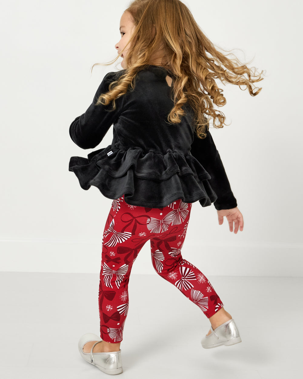 Child in motion wearing the Black Velvet Tiered Peplum Top