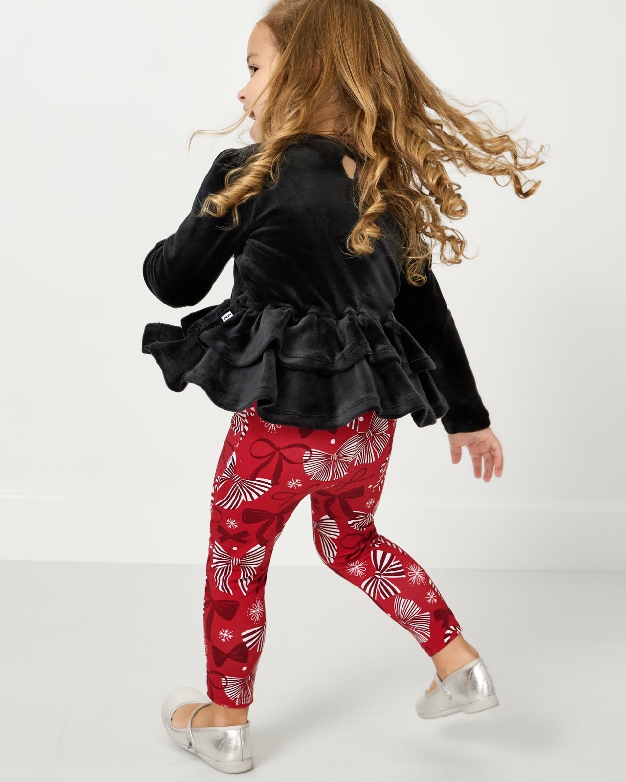 Child in motion wearing the Black Velvet Tiered Peplum Top