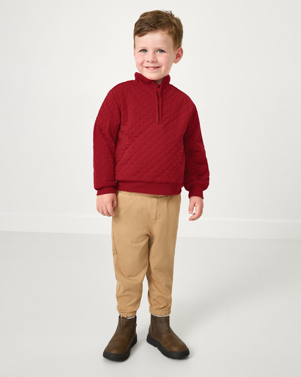 Standing boy wearing the Holiday Red Quilted Zip Pullover with khaki pants