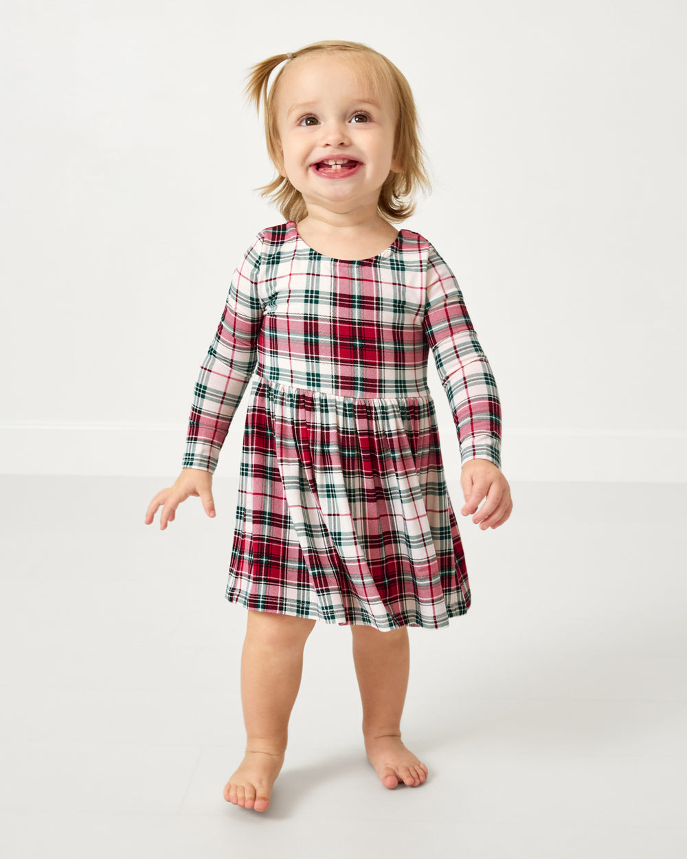 Standing toddler wearing the Holly Plaid Bow Back Skater Dress with Bodysuit