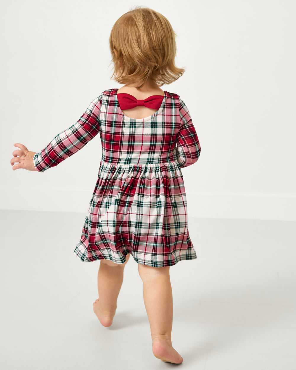 Back view of toddler wearing the Holly Plaid Bow Back Skater Dress with Bodysuit