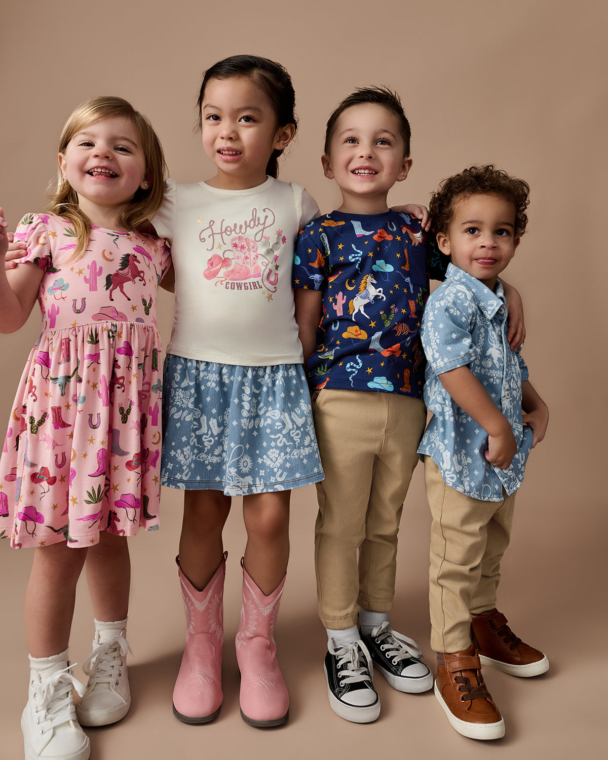 Group of four children wearing styles from the Rancher Roundup and Bandana Blues collection