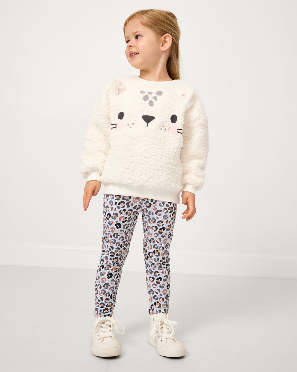 Girl wearing the Snowy Leopard Legging with a sherpa sweatshirt 