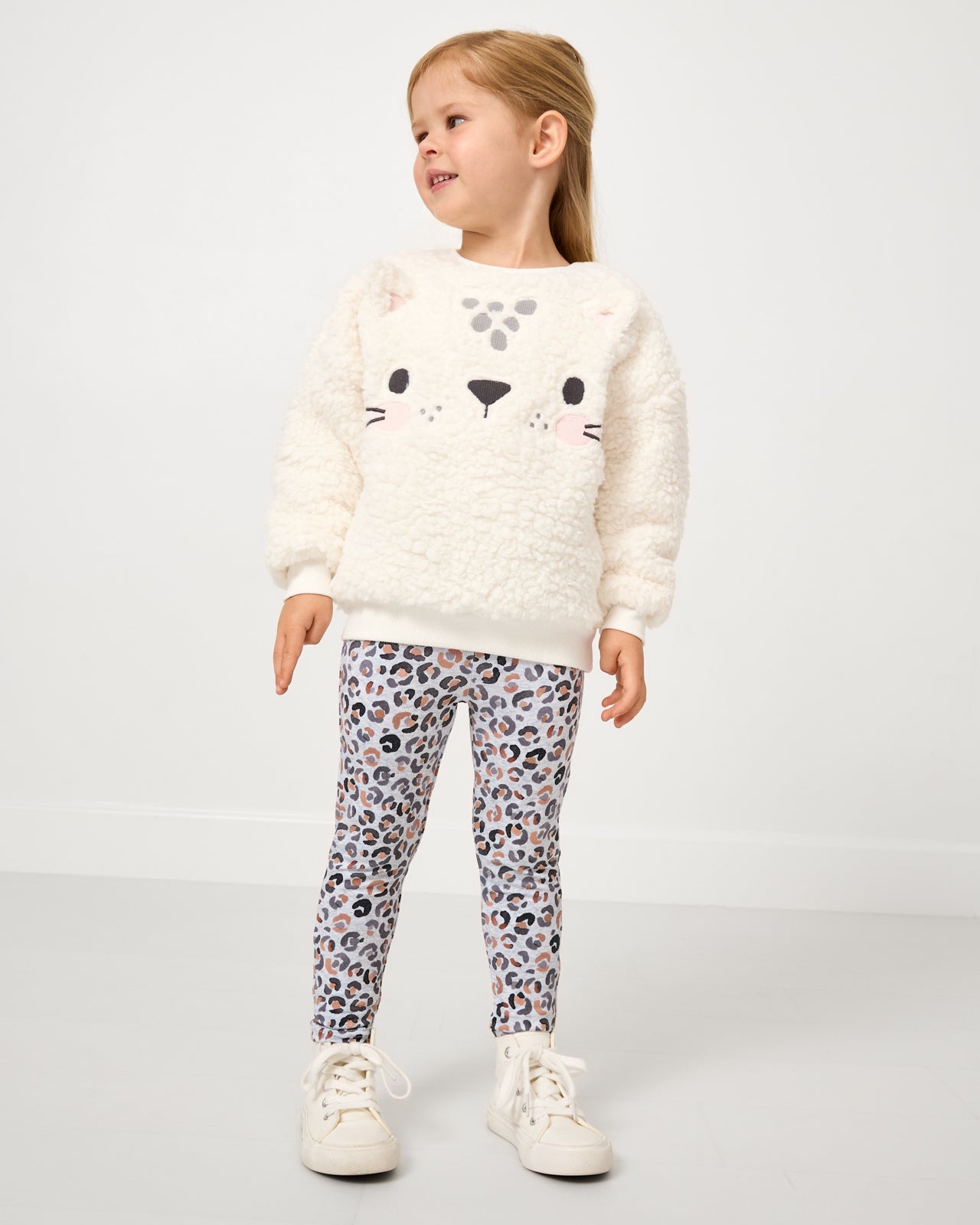 Girl wearing the Snowy Leopard Legging with a sherpa sweatshirt 