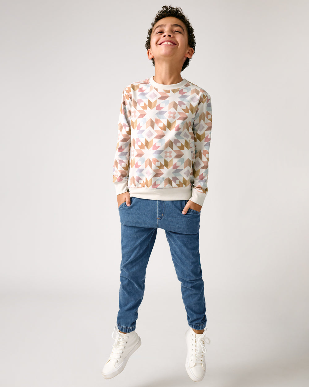 Boy wearing the Kaleidoscope Dreams Crewneck Sweatshirt and denim joggers