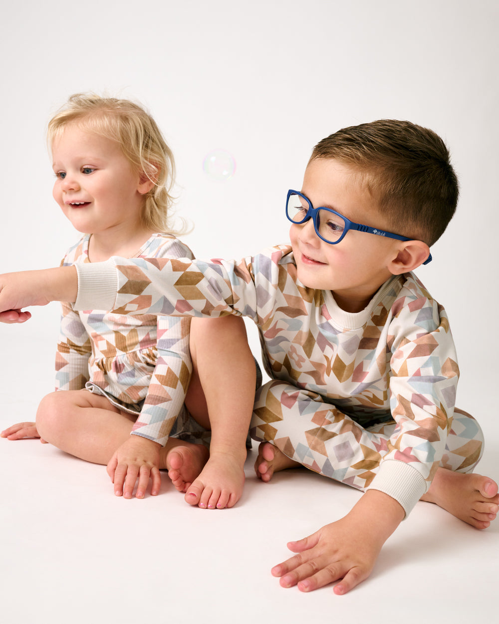 Two children wearing matching Kaleidoscope Dreams play styles