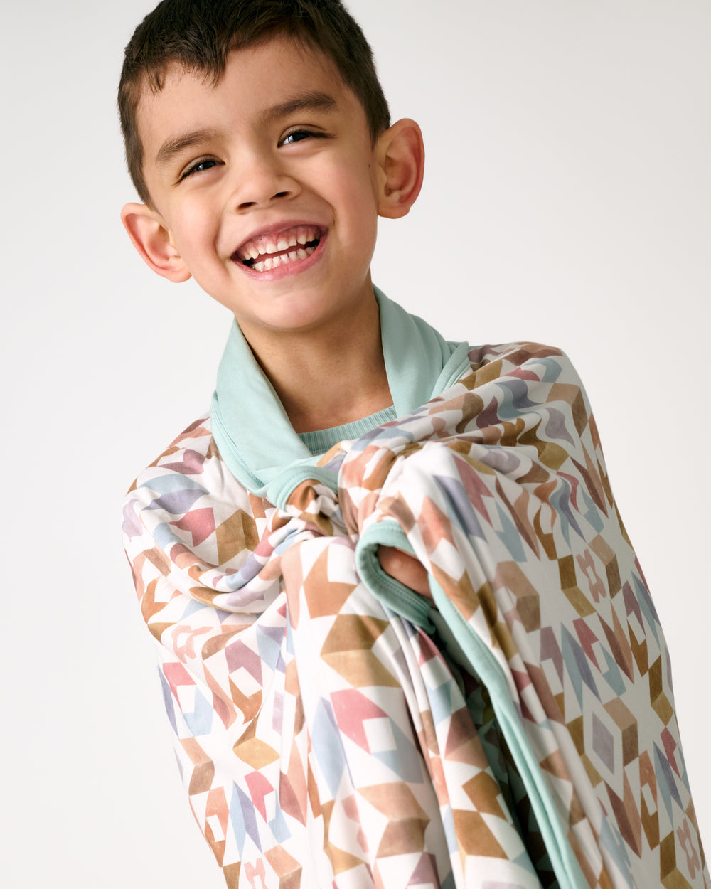 Standing boy wrapped in the Kaleidoscope Dreams Large Cloud Blanket®
