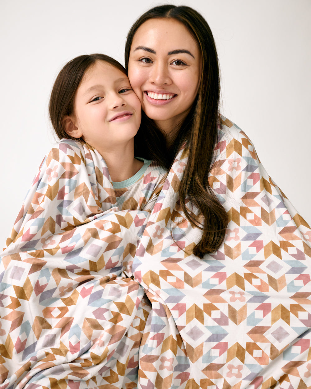 Close up of mother and daughter covered with the Kaleidoscope Dreams Oversized Cloud Blanket®