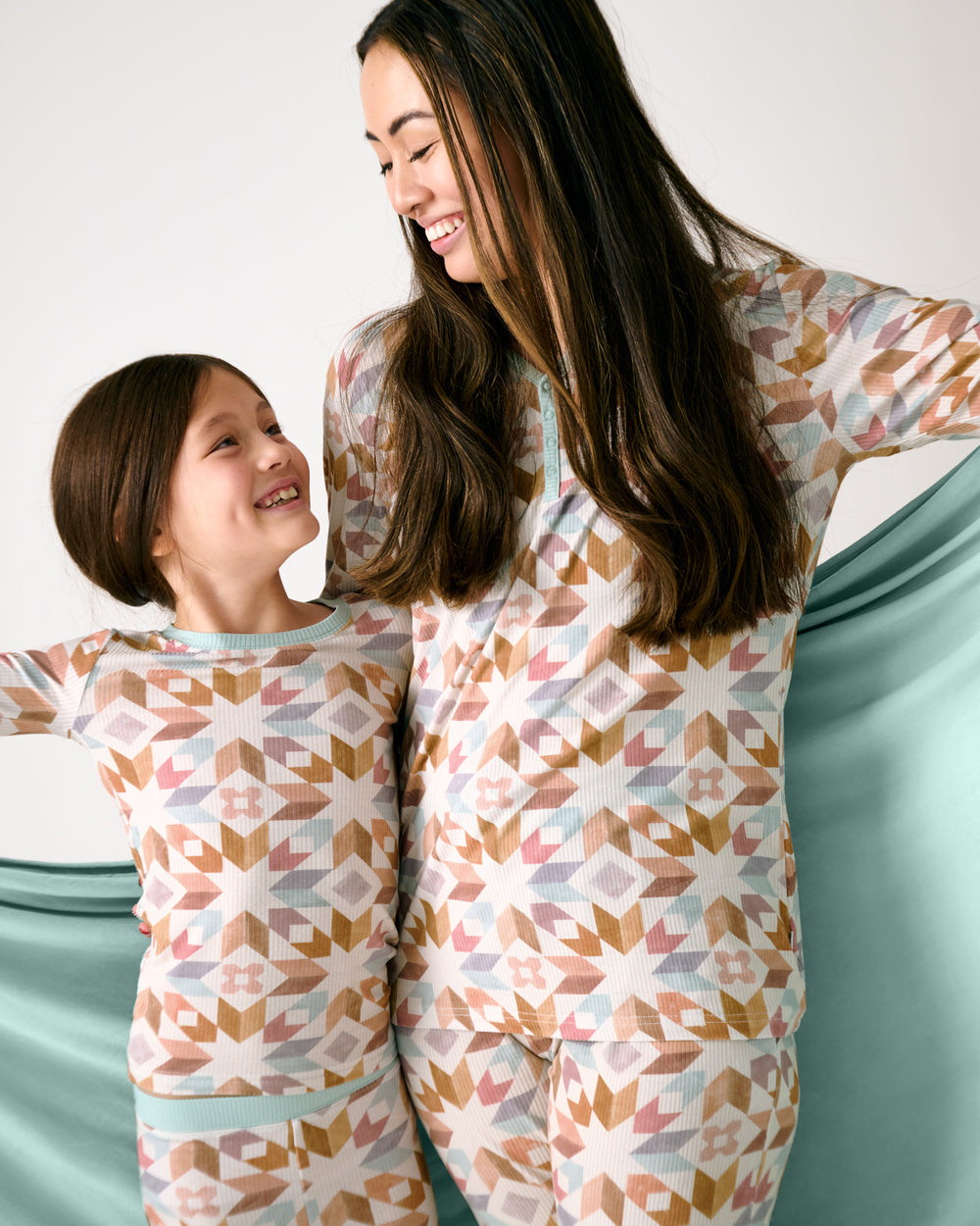 Mother and daughter holding the Kaleidoscope Dreams Oversized Cloud Blanket® showing the solid green side