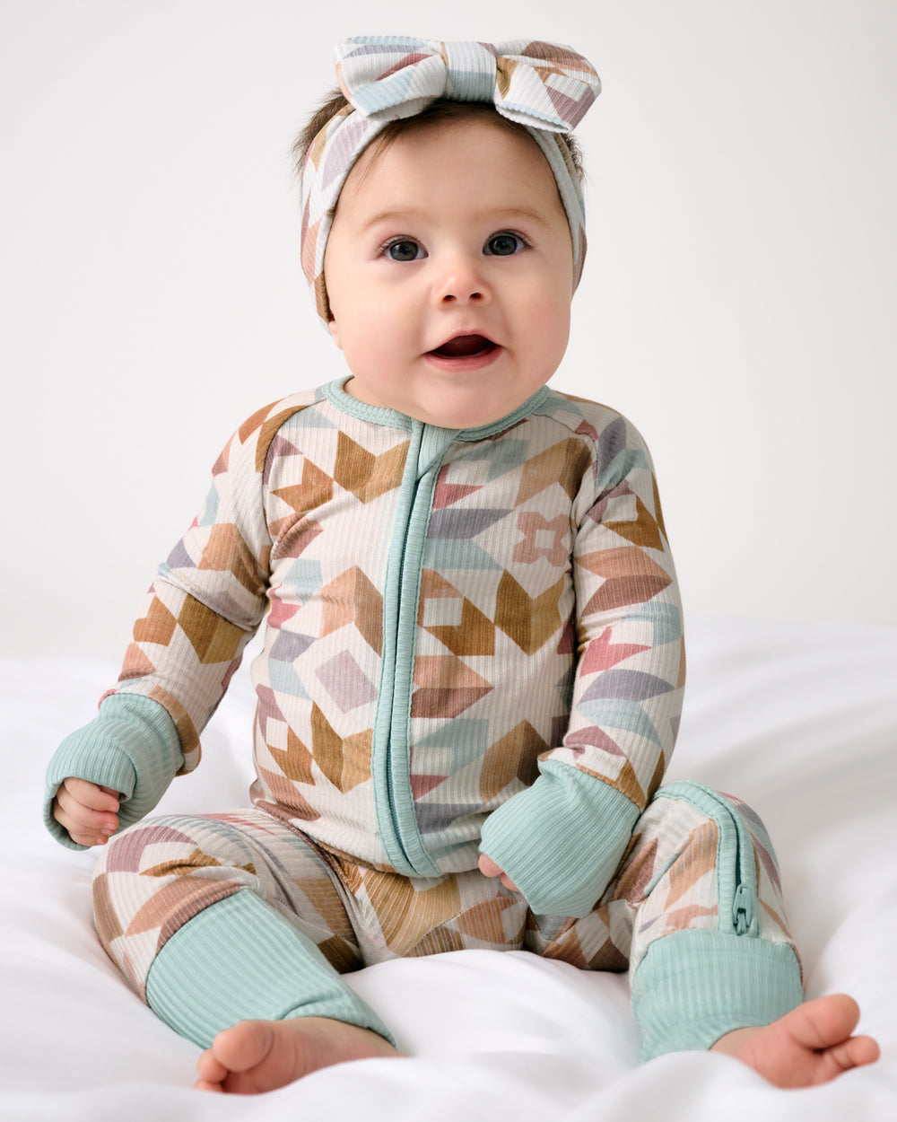 Sitting baby wearing the Kaleidoscope Dreams Ribbed Luxe Bow Headband
