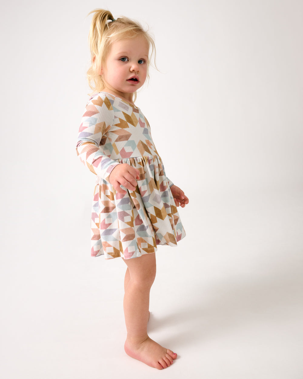 Walking toddler wearing the Kaleidoscope Dreams Ribbed Skater Dress with Bodysuit