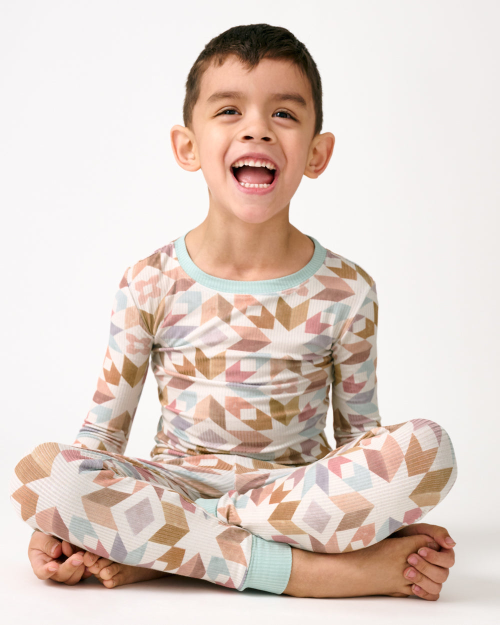 Sitting boy wearing the Kaleidoscope Dreams Ribbed Two-Piece Pajama Set