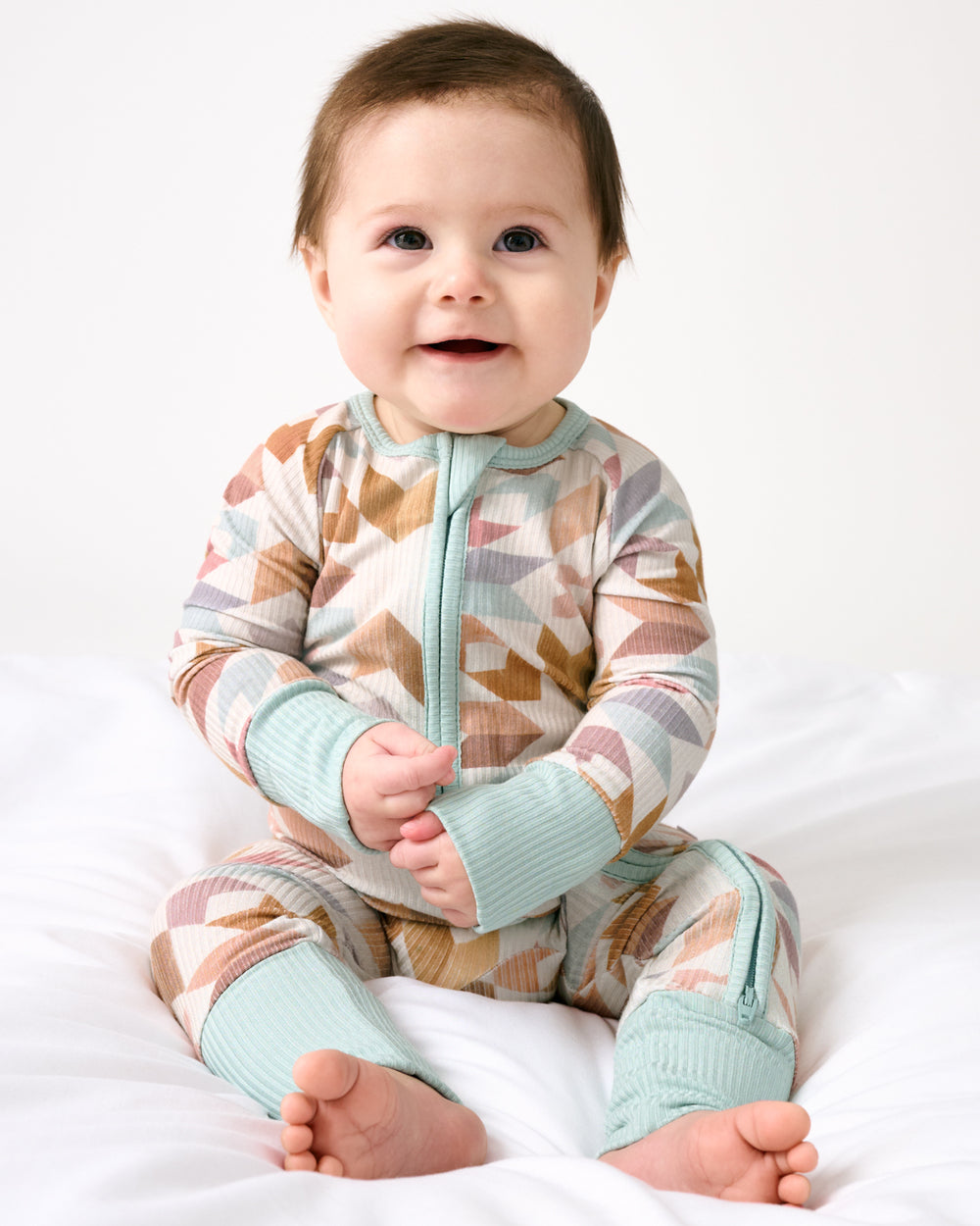 Sitting baby wearing the Kaleidoscope Dreams Ribbed Zippy