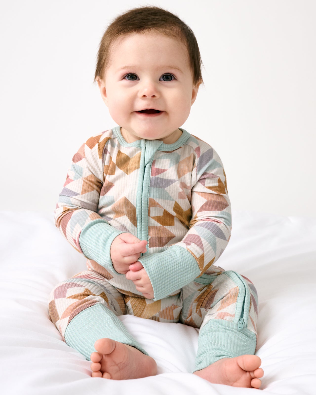 Sitting baby wearing the Kaleidoscope Dreams Ribbed Zippy
