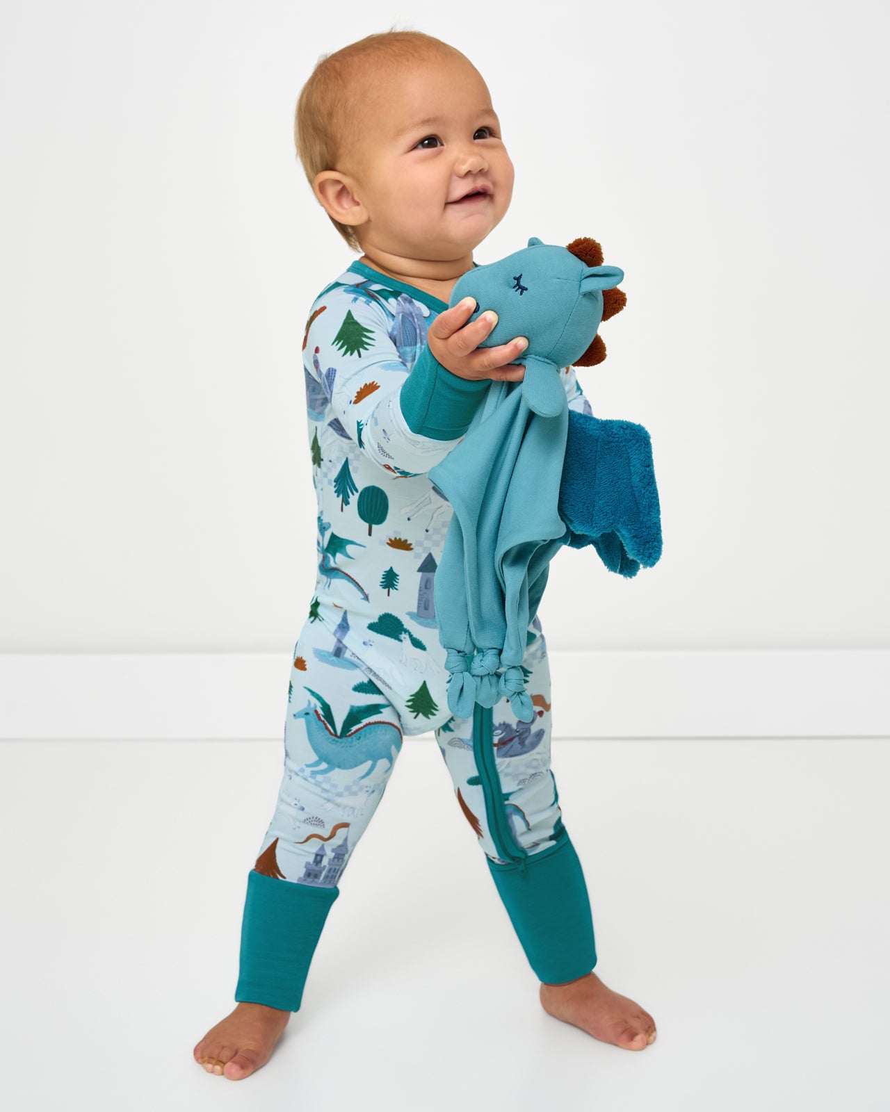 Toddler holding the Spark the Dragon Sleepyhead Lovey 