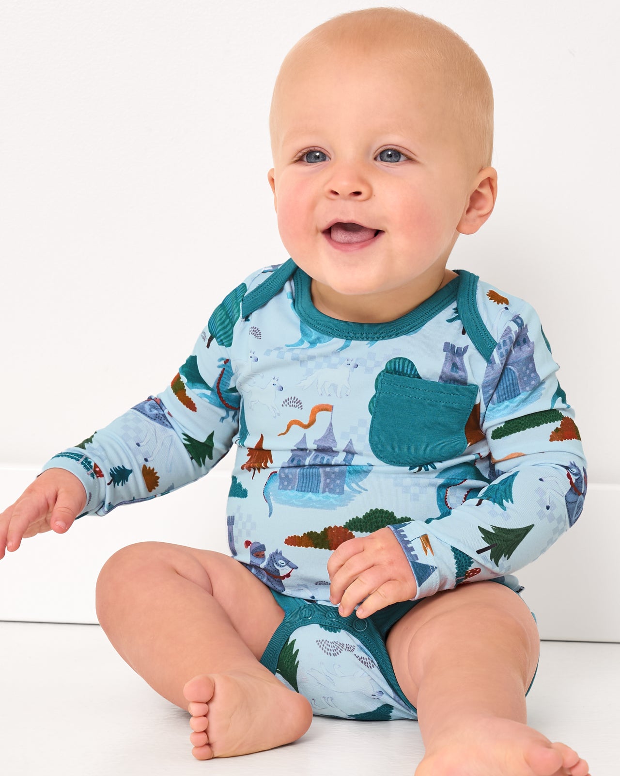 Sitting baby wearing the Knight's Quest Pocket Bodysuit