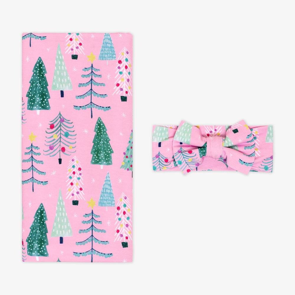 Flat lay image of a Pink Twinkling Trees Swaddle and Luxe Bow Headband Set