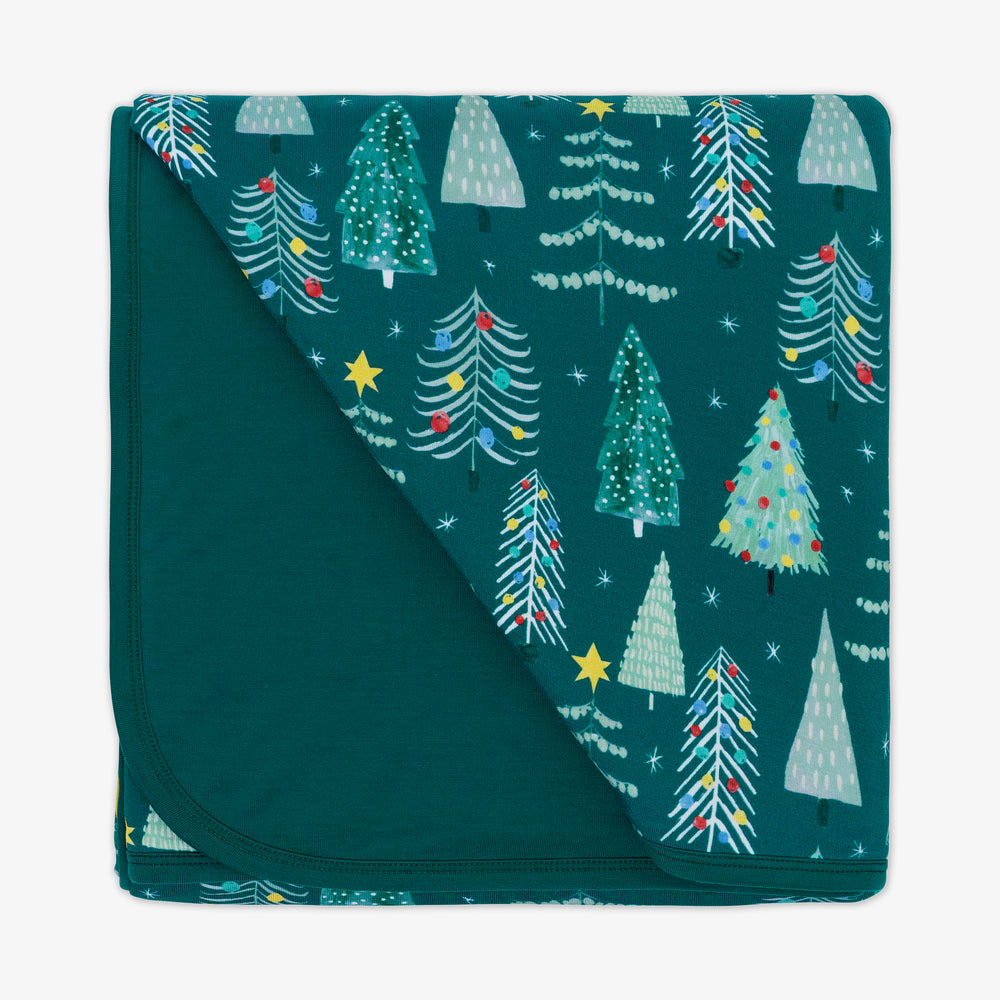 Flat lay image of the Green Twinkling Trees Large Cloud Blanket® folded