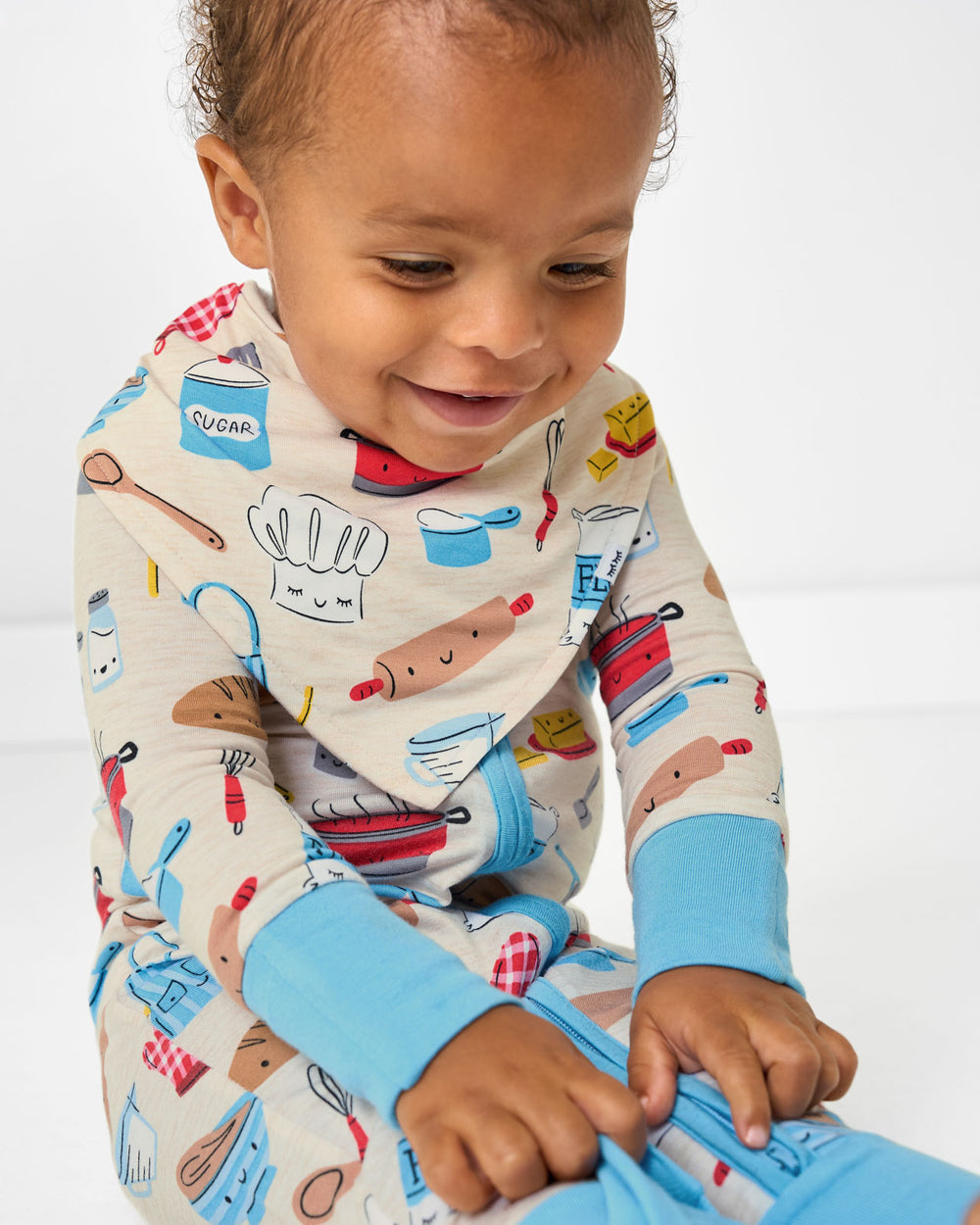 Alternate sitting baby wearing the Little Chef Bandana Bib and ZIppy