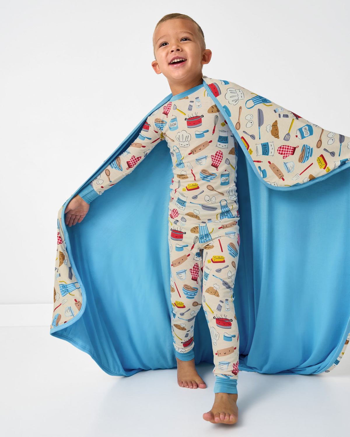Boy holding up the Little Chef Large Cloud Blanket® showing the solid blue side