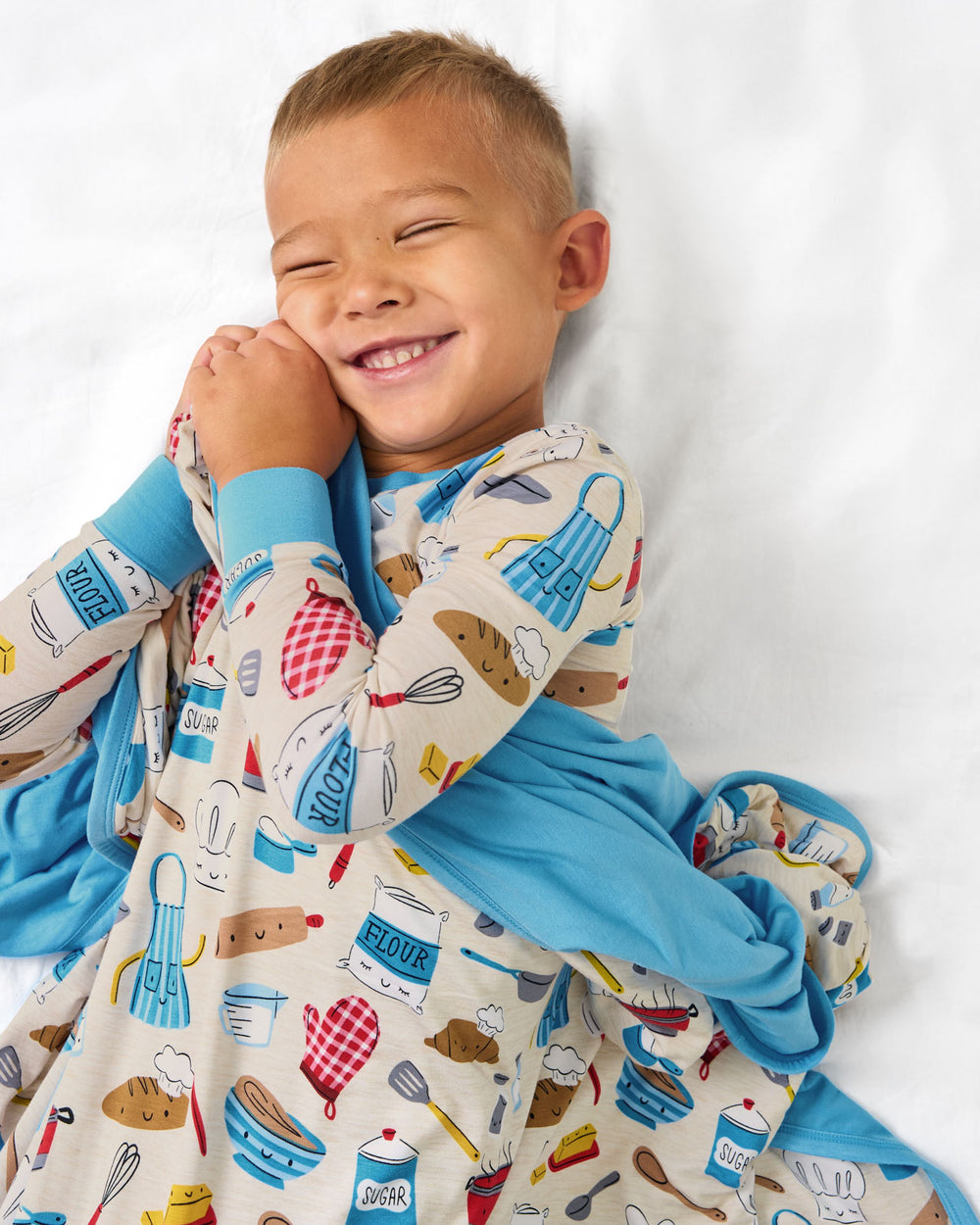 Aerial view of child snuggled in the Little Chef Large Cloud Blanket®