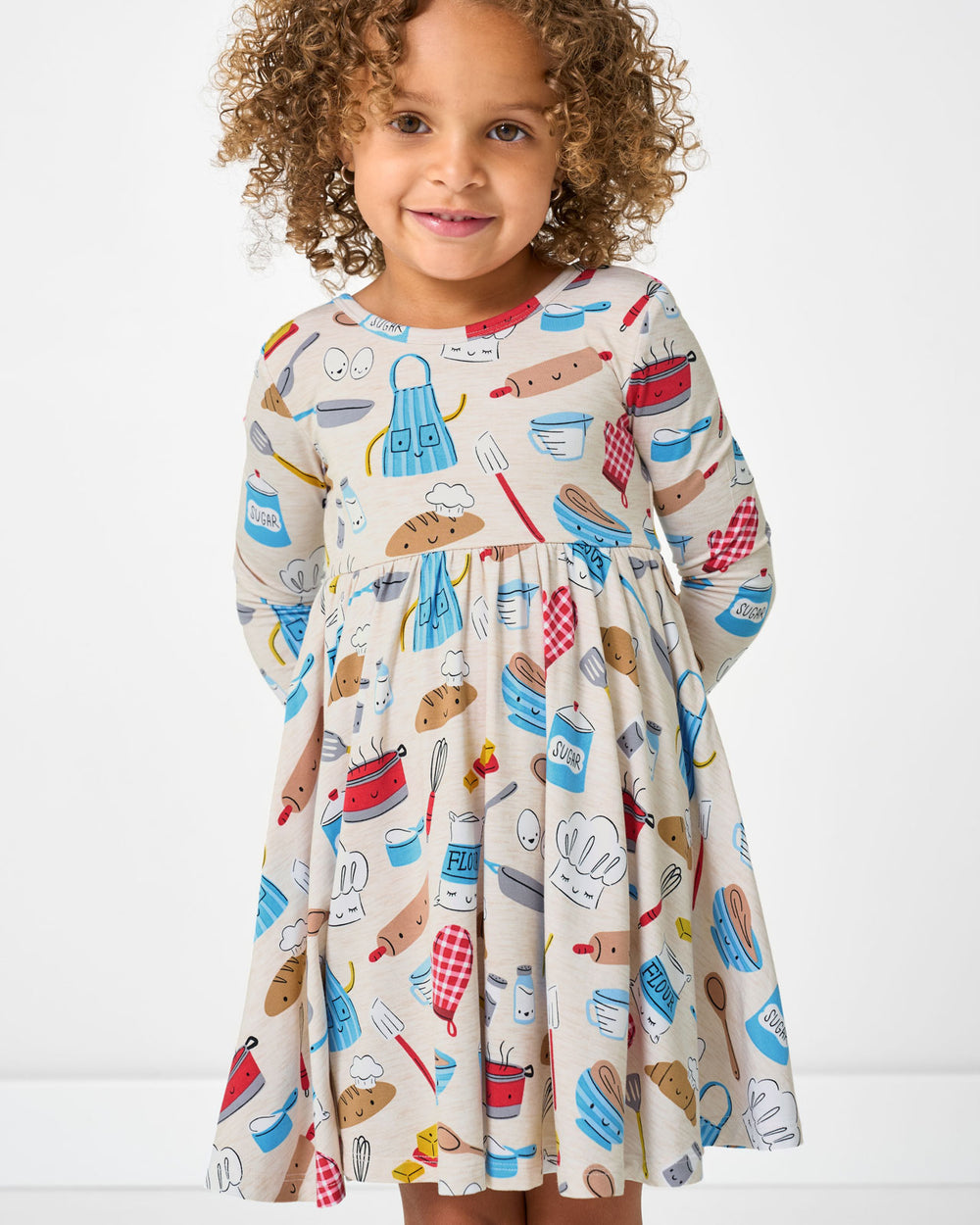 Close up of standing girl wearing the Little Chef Twirl Dress