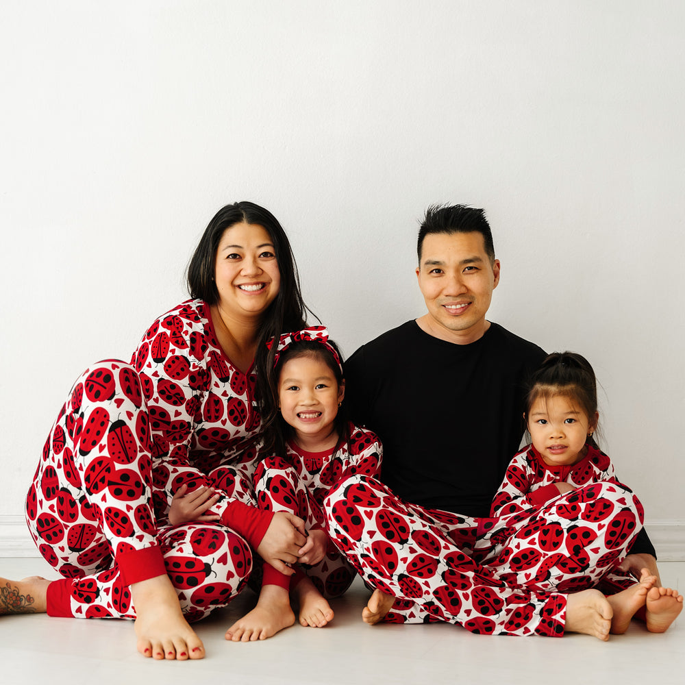 Click to see full screen - Family of four wearing matching Love Bug printed pajamas