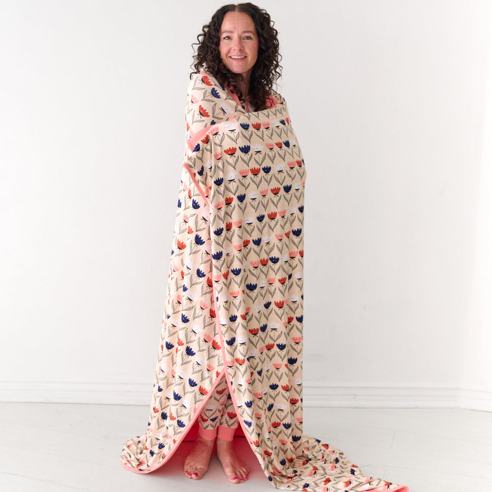 Woman wrapped up in a Flower Friends oversized cloud blanket