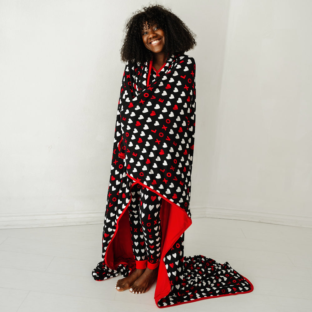 Click to see full screen - Image of a woman wrapped up in a Black XOXO Oversized Cloud Blanket