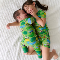 Two children laying on a blanket wearing matching Fairway Fun pajamas