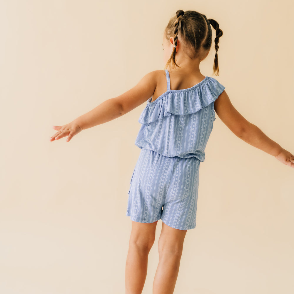 Back view of a child wearing an Island stripe asymmetrical romper