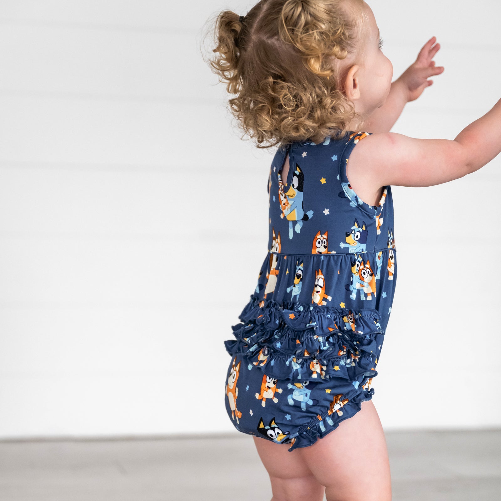 Image of girl wearing the Bluey Dance Mode Bubble Romper and showing ruffle detail on the back of the 