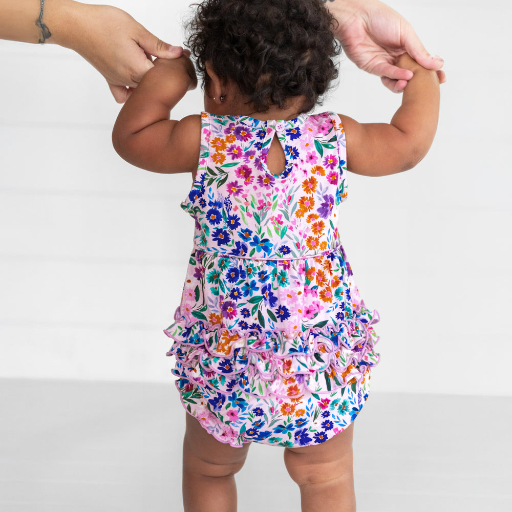 Back view image of a child wearing a Sweet Pea Floral Bubble Romper