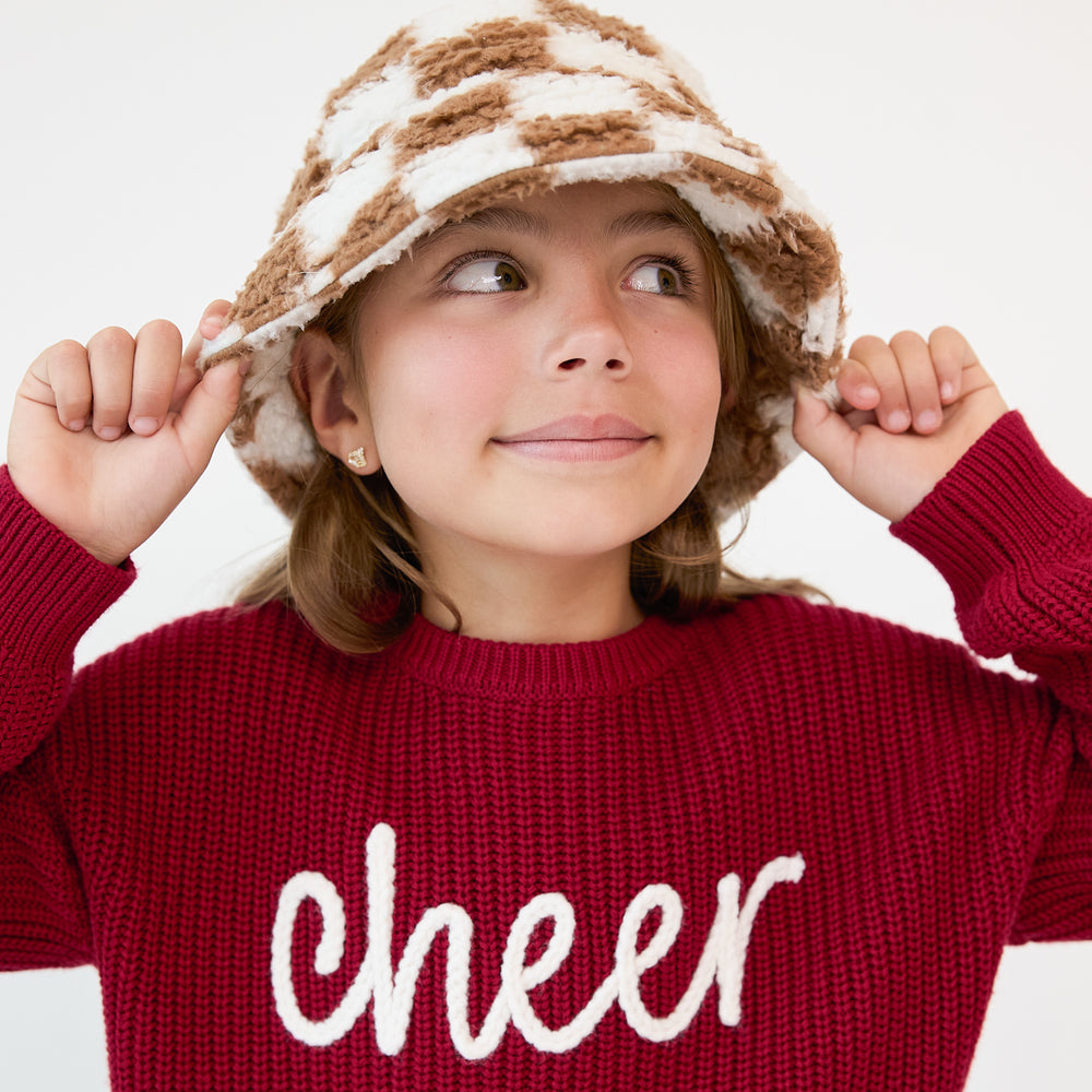 Close up image of a child wearing a Caramel Checks Sherpa Bucket Hat