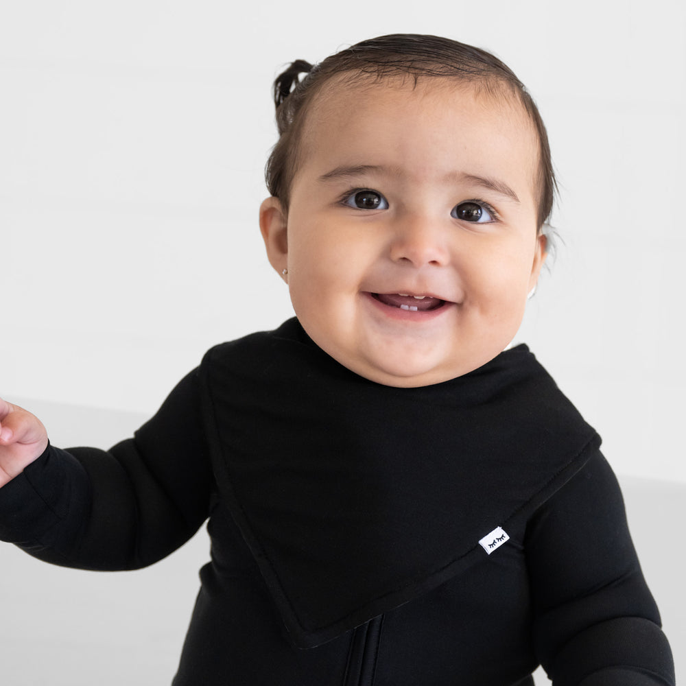 alternate close up image of a child wearing a Black bandana bib over a black zippy