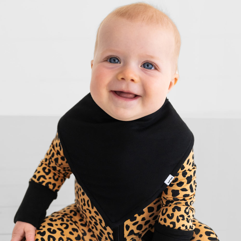 Close up image of a child wearing a Black bandana bib