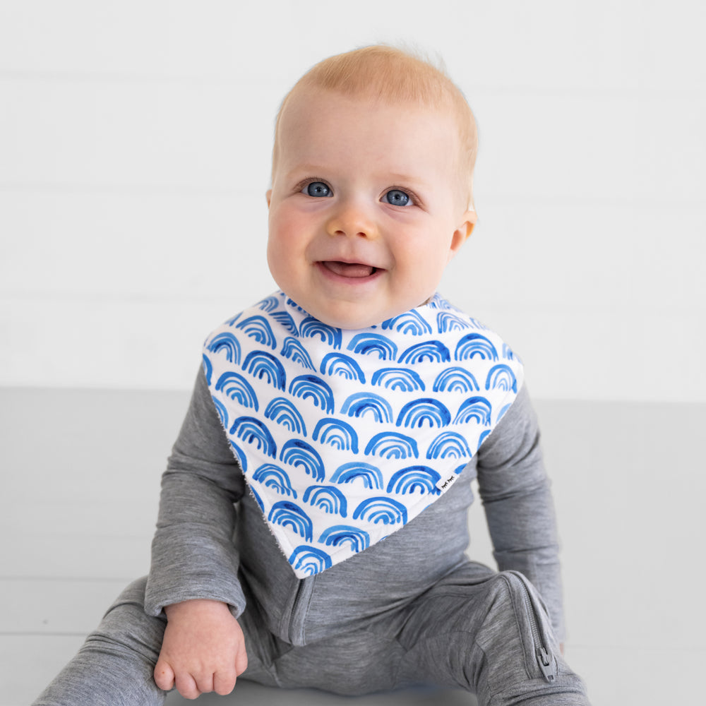 Close up image of a child wearing a Blue Rainbows bandana bib