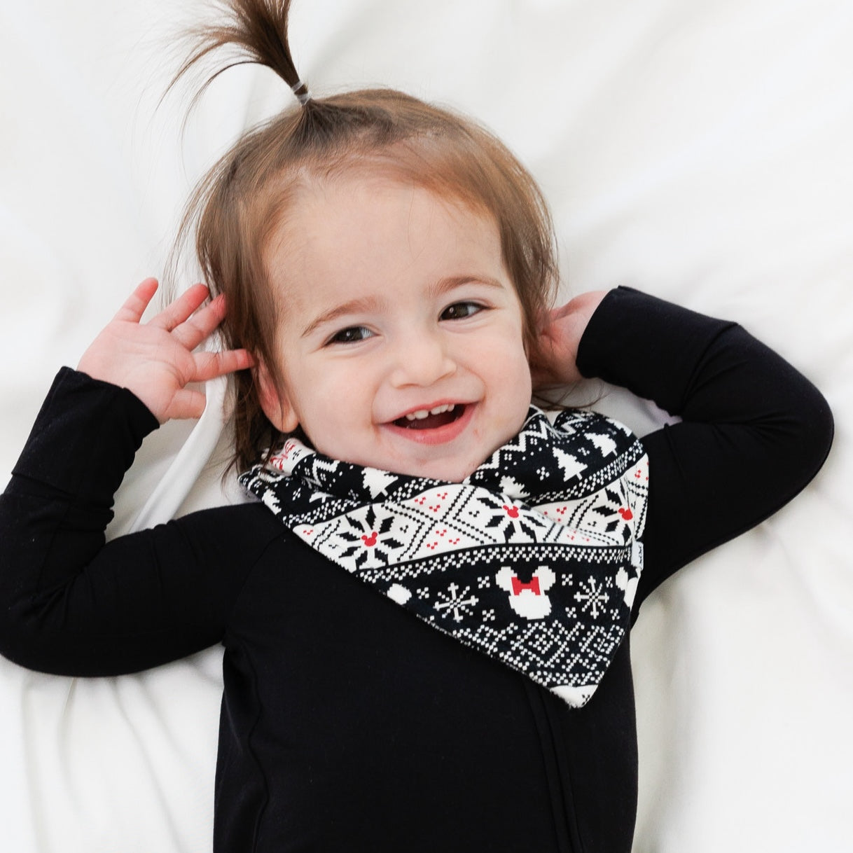 Close up image of a child wearing Mickey Fair Isle bandana bib and black zippy