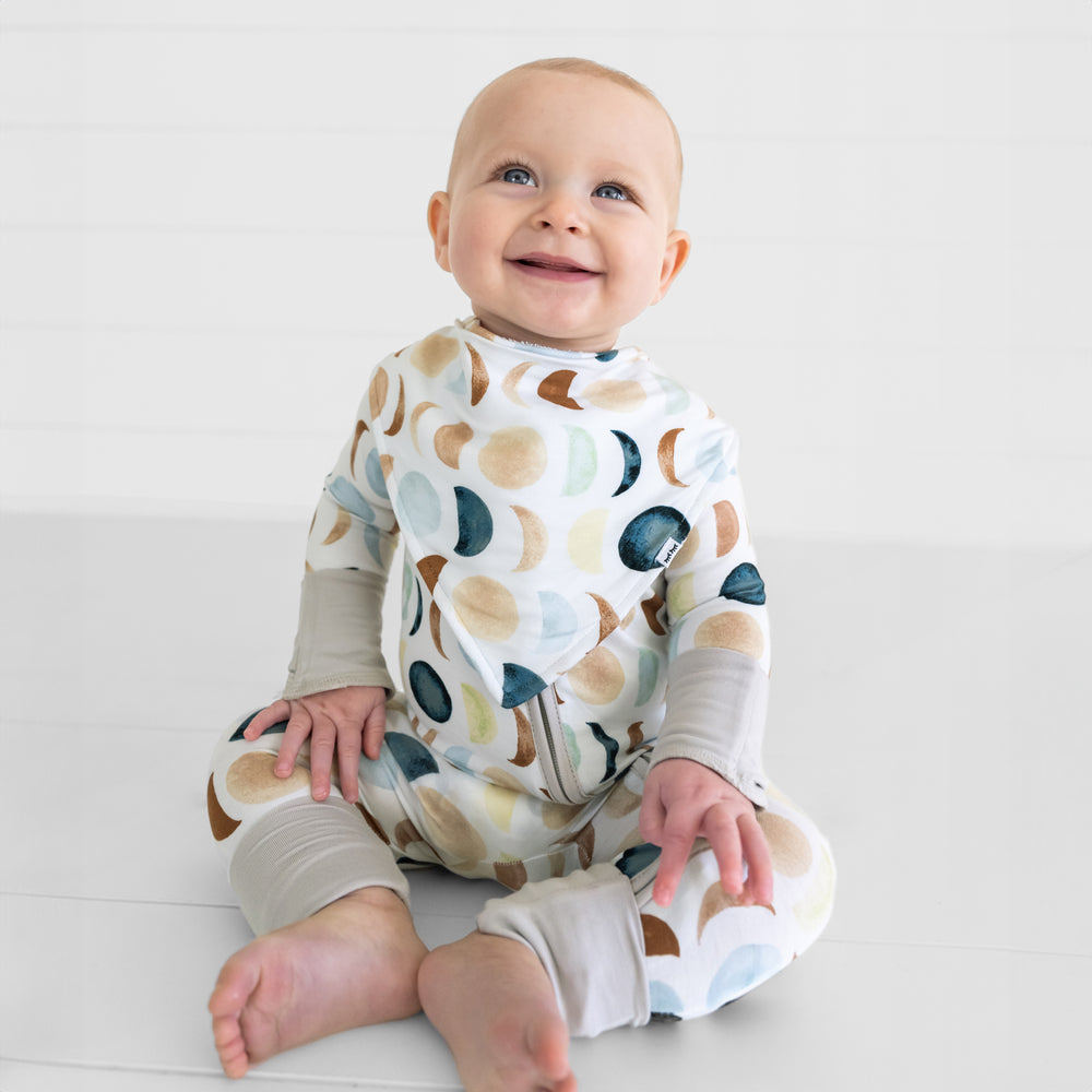 image of a child wearing a Luna Neutral bandana bib over a matching zippy