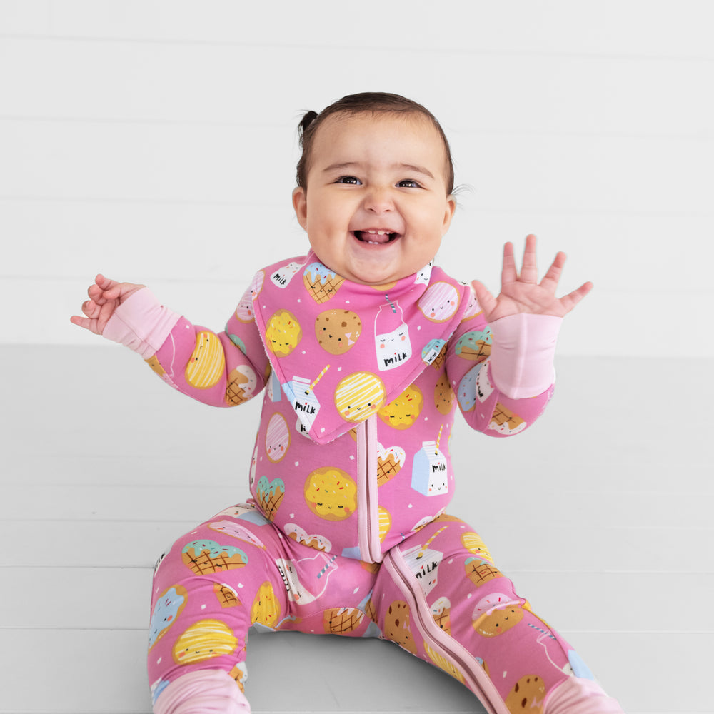  image of a child wearing a Pink Cookies and Milk bandana bib over a matching zippy