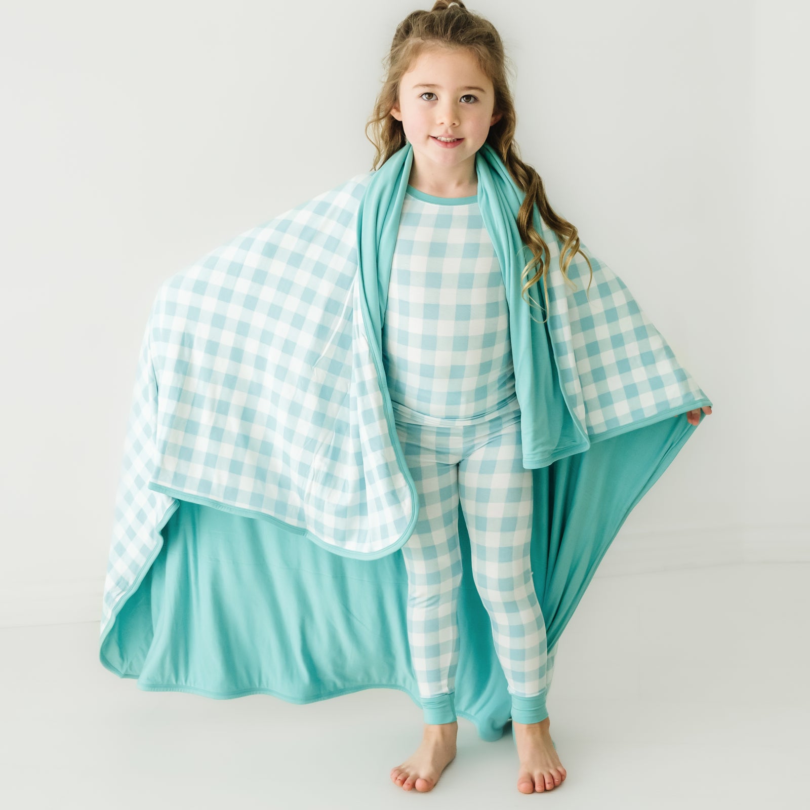 Alternate image of a child wearing a Aqua Gingham cloud blanket over her shoulders and a matching aqua gingham two piece pajama set