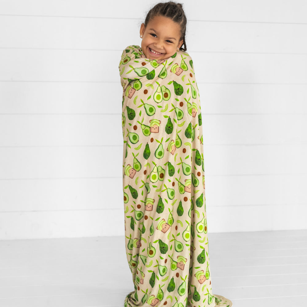 child wrapped up in an Avocado Toast cloud blanket 