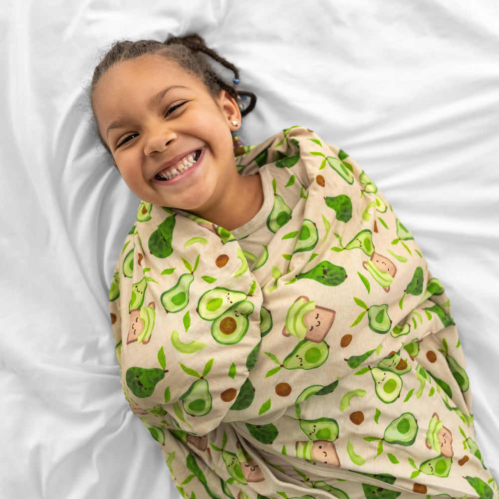 close up image of a child wrapped up in an Avocado Toast cloud blanket 