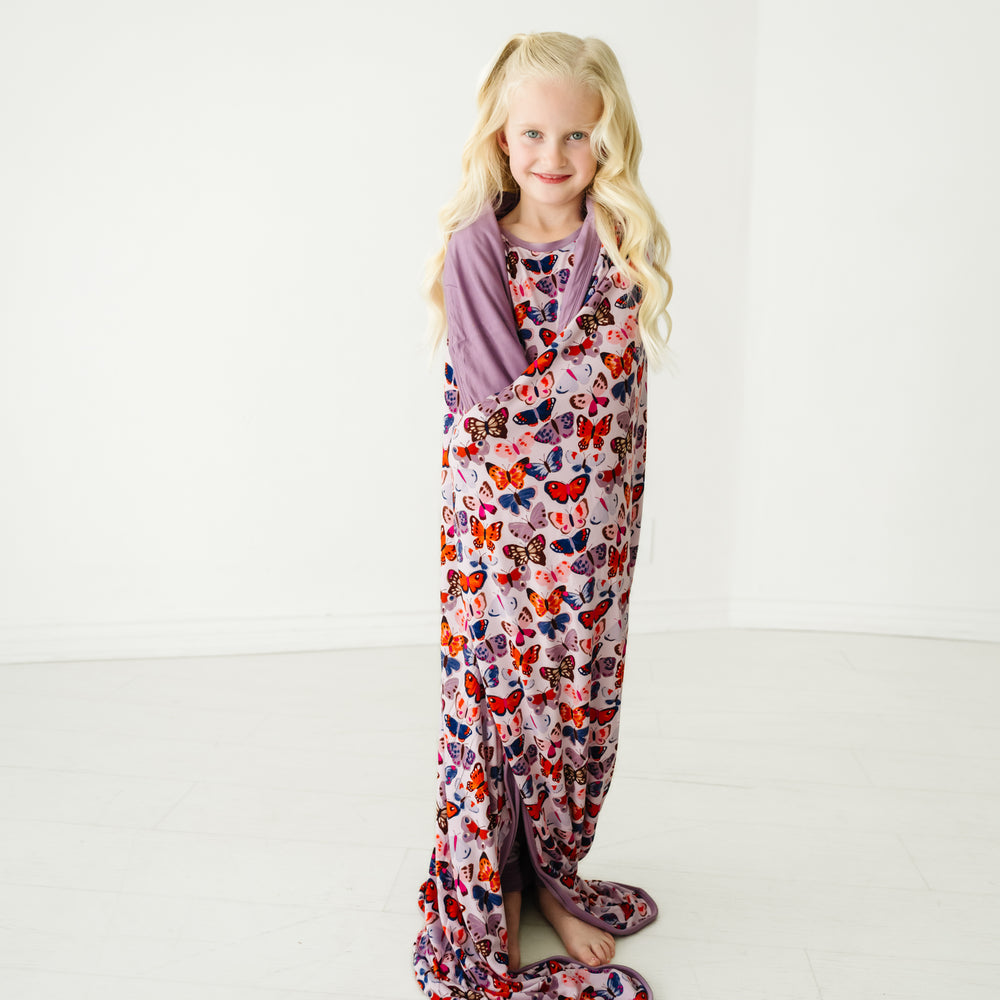 Child wrapped up in a Butterfly Kisses large cloud blanket wearing matching pajamas