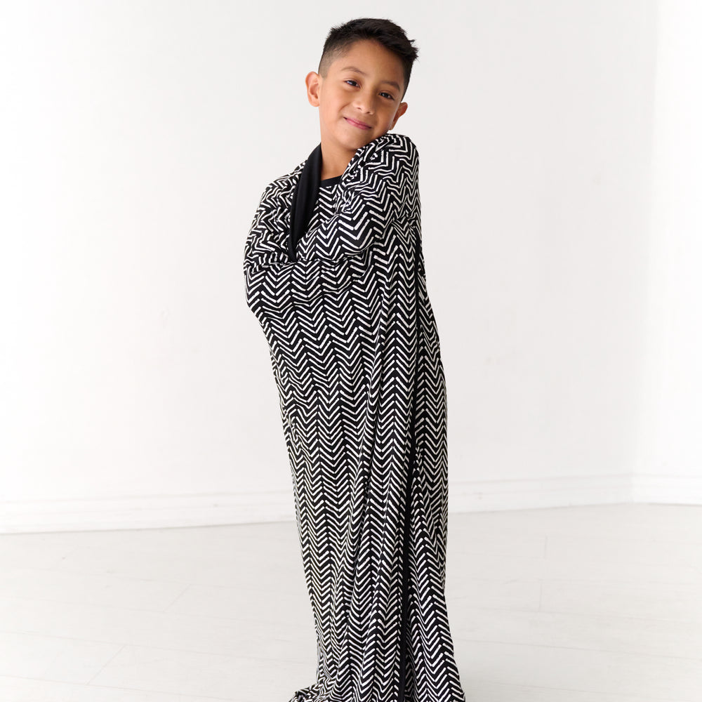 Child wrapped up in a Monochrome Chevron large cloud blanket