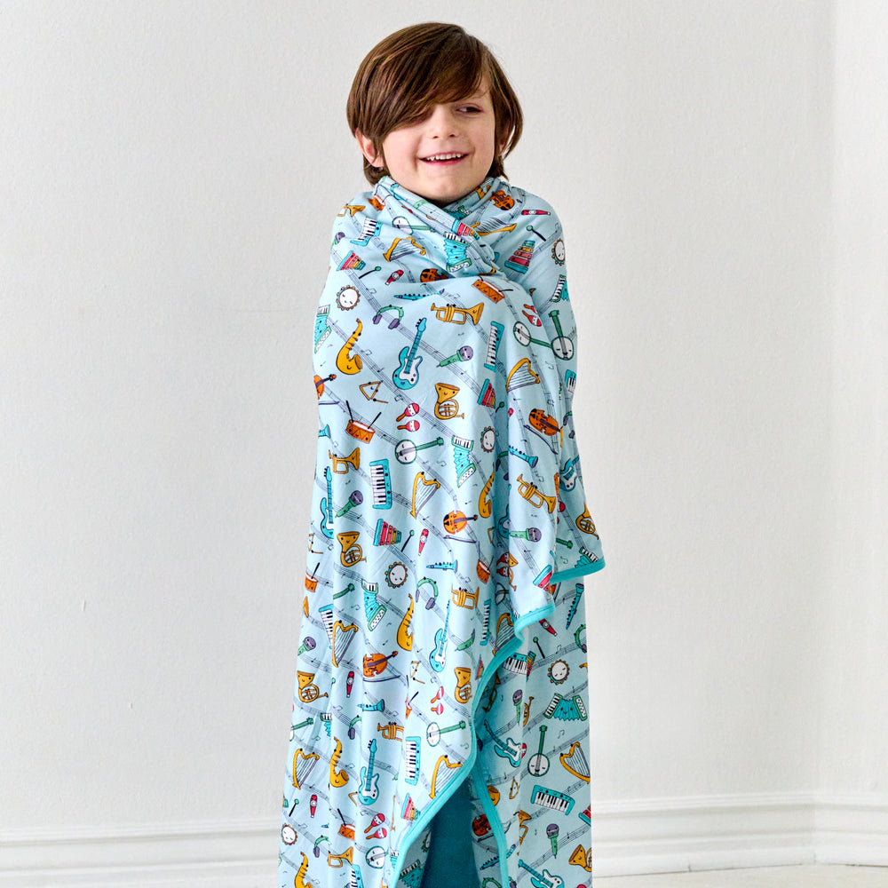 Child wrapped up in a Play Along large cloud blanket