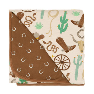 Flat lay image of a Caramel Ready to Rodeo large cloud blanket showing off the horseshoe printed backing