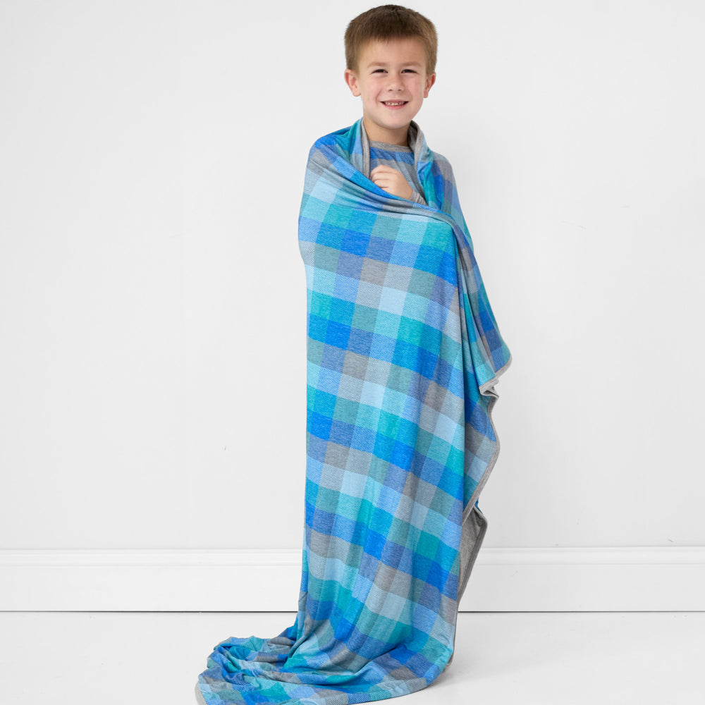 Image of a child wrapped in an Arctic Plaid cloud blanket